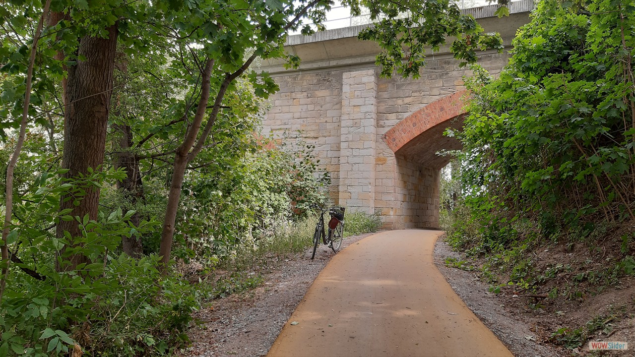 Hier fährt man unter der Brücke der ehemaligen Kanonenbahn.